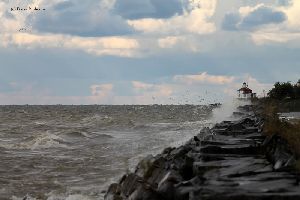 Waves smash against the seawall.