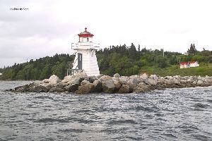 The lighthouse sits at the end of a breakwater.
