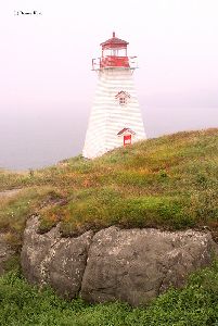 The lighthouse sits high up on a cliff.