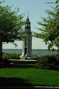 The lighthouse sits on the shore of the lake.