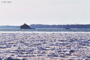 Distance shot of Buffalo Intake Crib and Horseshoe Reef lighthouses with ice in lake.