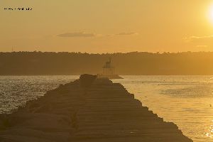 A beautiful sunset casts an orange glow on the Dog Bar Breakwater Light.