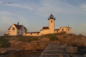 The setting sun casts a warm glow on the Eastern Point Lighthouse.