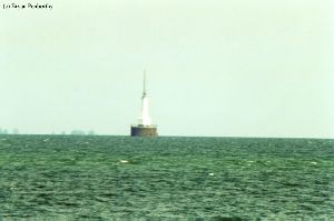 Distance shot of lighthouse out in the water.