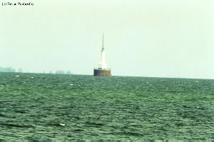 Distance shot of lighthouse out in the water.