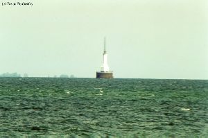 Distance shot of lighthouse out in the water.