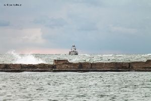 Waves crash over the breakwall near the Horseshoe Reef Lighthouse.