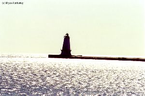 Bright sunlight shadows the lighthouse.
