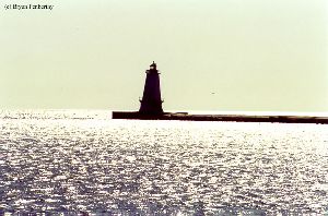 Bright sunlight shadows the lighthouse.