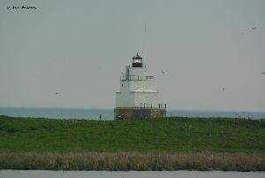 Man fishes near the lighthouse.