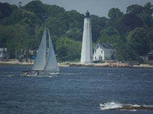 A sailboat passes the tower.
