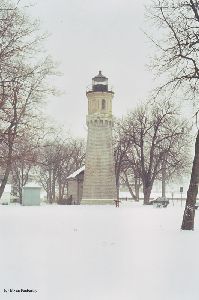 Lighthouse with snowy grounds.