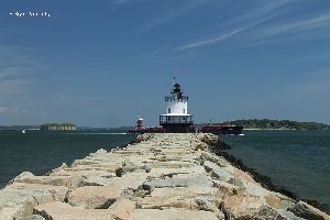 A ship safely passes by the Spring Point Ledge Lighthouse.