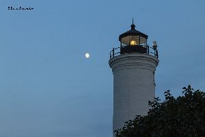 Tibbetts Point Lighthouse at dusk, with moon rising.